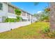 Exterior view of a light gray building with a white fence and landscaping at 5820 43Rd N Ter # 1403, St Petersburg, FL 33709
