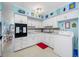 Well-equipped kitchen featuring white cabinets and a view of living area at 5820 43Rd N Ter # 1403, St Petersburg, FL 33709