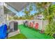 Small patio with artificial turf, red chairs, and a grill at 5820 43Rd N Ter # 1403, St Petersburg, FL 33709