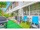 Small patio with artificial turf, blue chairs, and a grill at 5820 43Rd N Ter # 1403, St Petersburg, FL 33709