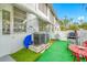 Small patio with artificial turf, red chairs, and a grill at 5820 43Rd N Ter # 1403, St Petersburg, FL 33709
