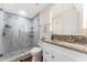Modern bathroom boasts a glass-enclosed shower with gray tile, updated vanity, and granite countertop at 727 53Rd N Ter, St Petersburg, FL 33703
