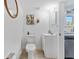 Bathroom features a toilet, a sink, a mirror and decor with neutral paint and tiling at 727 53Rd N Ter, St Petersburg, FL 33703