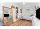 Bright bedroom with a decorative mirror, a bed with a geometric patterned cover, and wood floors at 727 53Rd N Ter, St Petersburg, FL 33703