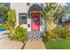 Inviting home exterior features a pink door, patterned tile, and lush, tropical landscaping at 727 53Rd N Ter, St Petersburg, FL 33703