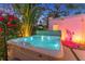 Backyard hot tub with colorful lights and tropical foliage for evening enjoyment at 727 53Rd N Ter, St Petersburg, FL 33703