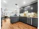 Stylish kitchen with dark gray cabinetry, stainless appliances, and an open view to the living room at 727 53Rd N Ter, St Petersburg, FL 33703