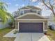 Two-story house with gray siding, dark gray garage door, and landscaped yard at 8023 Carriage Pointe Dr, Gibsonton, FL 33534