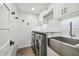 Bright laundry room with farmhouse style cabinets, marble countertop, and modern appliances at 8215 Cosme Rd, Odessa, FL 33556