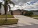 House exterior with a two-car garage and landscaped lawn at 9734 Sage Creek Dr, Sun City Center, FL 33573