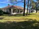 Spacious backyard features a screened-in patio, green lawn, and mature trees at 11405 Warm Wind Way, Weeki Wachee, FL 34613