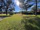 Large backyard with green grass, trees, and a clear blue sky at 11405 Warm Wind Way, Weeki Wachee, FL 34613