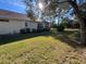 Well-maintained backyard with lush green grass and mature trees on a sunny day at 11405 Warm Wind Way, Weeki Wachee, FL 34613