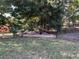 Landscaped backyard area with a wooden-bordered flower bed and chain-link fence at 11405 Warm Wind Way, Weeki Wachee, FL 34613