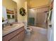 Well-lit bathroom features a vanity, shower, and tub combo with framed sliding glass doors at 11405 Warm Wind Way, Weeki Wachee, FL 34613