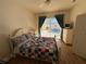 Bedroom with natural light, wood floors, a quilt, and views of the screened-in pool area at 11405 Warm Wind Way, Weeki Wachee, FL 34613