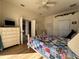 Comfortable bedroom featuring a colorful quilt, a ceiling fan, and light wood floors at 11405 Warm Wind Way, Weeki Wachee, FL 34613