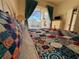 Cozy bedroom showcases a decorative quilt and bright windows offering a view of the outdoor pool at 11405 Warm Wind Way, Weeki Wachee, FL 34613
