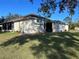 Exterior view of a home with a screened porch and landscaped backyard at 11405 Warm Wind Way, Weeki Wachee, FL 34613