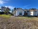Exterior home view featuring large arch window, stucco siding, and well-kept lawn at 11405 Warm Wind Way, Weeki Wachee, FL 34613