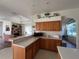 Open-concept kitchen features wood cabinets, modern appliances, and a view of the living area at 11405 Warm Wind Way, Weeki Wachee, FL 34613