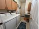 Efficient laundry room featuring a washer, dryer, utility sink, and ample cabinet space at 11405 Warm Wind Way, Weeki Wachee, FL 34613