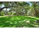 Expansive backyard with lush green grass and trees surrounding the house at 160 Bayshore Dr, Terra Ceia, FL 34250