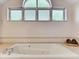 Relaxing bathroom with a large jetted tub and arched window at 1630 Royal Palm S Dr # A, St Petersburg, FL 33707