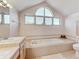 Bright bathroom with a soaking tub, double vanity, and tiled floors at 1630 Royal Palm S Dr # A, St Petersburg, FL 33707