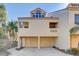 Two-story home exterior showcasing the two-car garage and a balcony at 1630 Royal Palm S Dr # A, St Petersburg, FL 33707