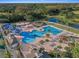 Aerial view of resort-style pool with multiple areas, spacious deck, and surrounding landscaping at 19301 Sandy Springs Cir, Lutz, FL 33558