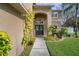 Front entryway of the house with lush greenery and a walkway at 19301 Sandy Springs Cir, Lutz, FL 33558