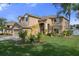Tan two-story house with nicely landscaped yard and a two-car garage at 19301 Sandy Springs Cir, Lutz, FL 33558