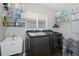 Laundry room with washer, dryer, shelving, and utility sink at 19301 Sandy Springs Cir, Lutz, FL 33558