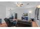 Relaxing living room with hardwood floors, ceiling fan, and comfortable seating at 19301 Sandy Springs Cir, Lutz, FL 33558