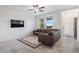 Spacious living room with brown leather sectional and ceiling fan at 31639 Blue Passing Loop, Wesley Chapel, FL 33545