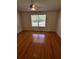 Empty bedroom with wood-look laminate floors, ceiling fan, and large window at 6023 Osprey Lake Cir, Riverview, FL 33578