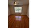 Empty bedroom with wood-look laminate floors, ceiling fan, and window at 6023 Osprey Lake Cir, Riverview, FL 33578