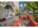 Red deck with patio furniture, tropical plants and a view of neighboring building at 609 S Glen Ave # B, Tampa, FL 33609