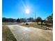 Sunny front yard with driveway and mature trees at 7521 Coventry Dr, Port Richey, FL 34668