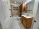 Clean bathroom with wood cabinets, large mirror and marble-look flooring at 8601 Twin Lakes Blvd, Tampa, FL 33614