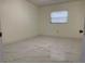 Well-lit bedroom with window, closet and marble-look flooring at 8601 Twin Lakes Blvd, Tampa, FL 33614