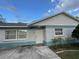 Inviting exterior of a single story home featuring light brick and a landscaped yard at 8601 Twin Lakes Blvd, Tampa, FL 33614