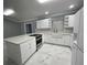 Modern kitchen with white cabinets, a farmhouse sink, and marble-look floors at 8601 Twin Lakes Blvd, Tampa, FL 33614