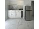 Efficient galley kitchen with white cabinets and marble-look floors at 8601 Twin Lakes Blvd, Tampa, FL 33614