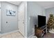Condo entryway with tiled floors, white door, and a large TV at 10265 Gandy N Blvd # 905, St Petersburg, FL 33702