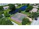 Aerial view of the community tennis courts surrounded by lush landscaping and nearby pond at 10265 Gandy N Blvd # 905, St Petersburg, FL 33702