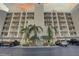 Exterior view of condo building with palm trees and parking at 1200 Country Club Dr # 2504, Largo, FL 33771
