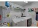 Well-equipped laundry room with washer, dryer, and shelving at 1200 Country Club Dr # 2504, Largo, FL 33771