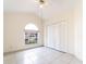 Bright bedroom featuring tile floors, a ceiling fan, an arched window, and a closet at 1515 Lions Club Dr, Brandon, FL 33511